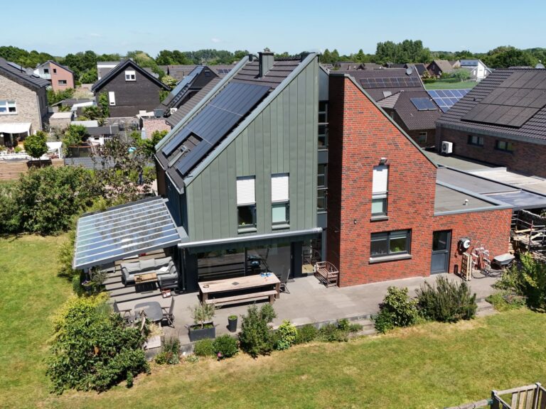 Photovoltaikanlage mit Full-Black Modulen auf modernem Ziegeldach eines Einfamilienhauses in Kevelaer – energieeffiziente Dachlösung mit Glas-Terrassenüberdachung im Neubaugebiet.