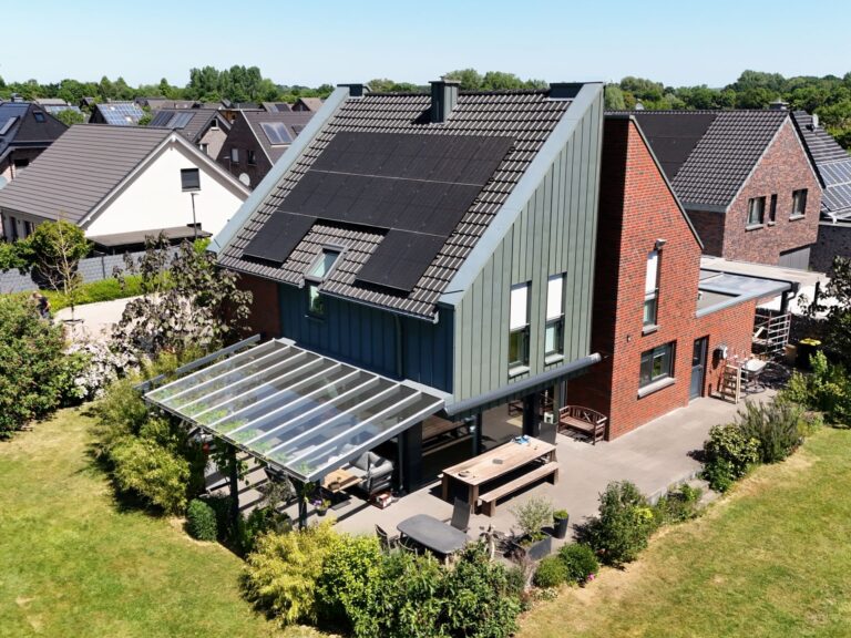 Einfamilienhaus mit moderner Photovoltaikanlage auf dem Ziegeldach in Kevelaer – Full-Black Solarmodule und Pultdach mit Glasüberdachung der Terrasse im Neubaugebiet.
