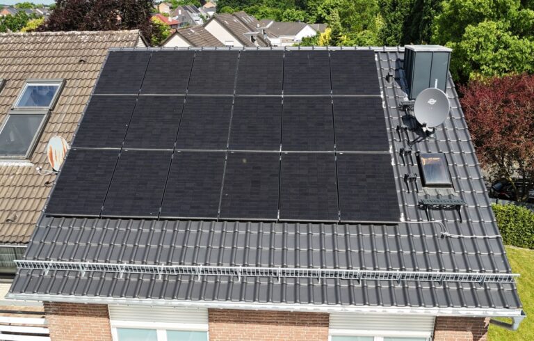 Photovoltaikanlage mit Full-Black Modulen auf saniertem Ziegeldach in Kevelaer – moderne Solartechnik auf Einfamilienhaus mit Dachfenster, Schneefang und Sat-Anlage.